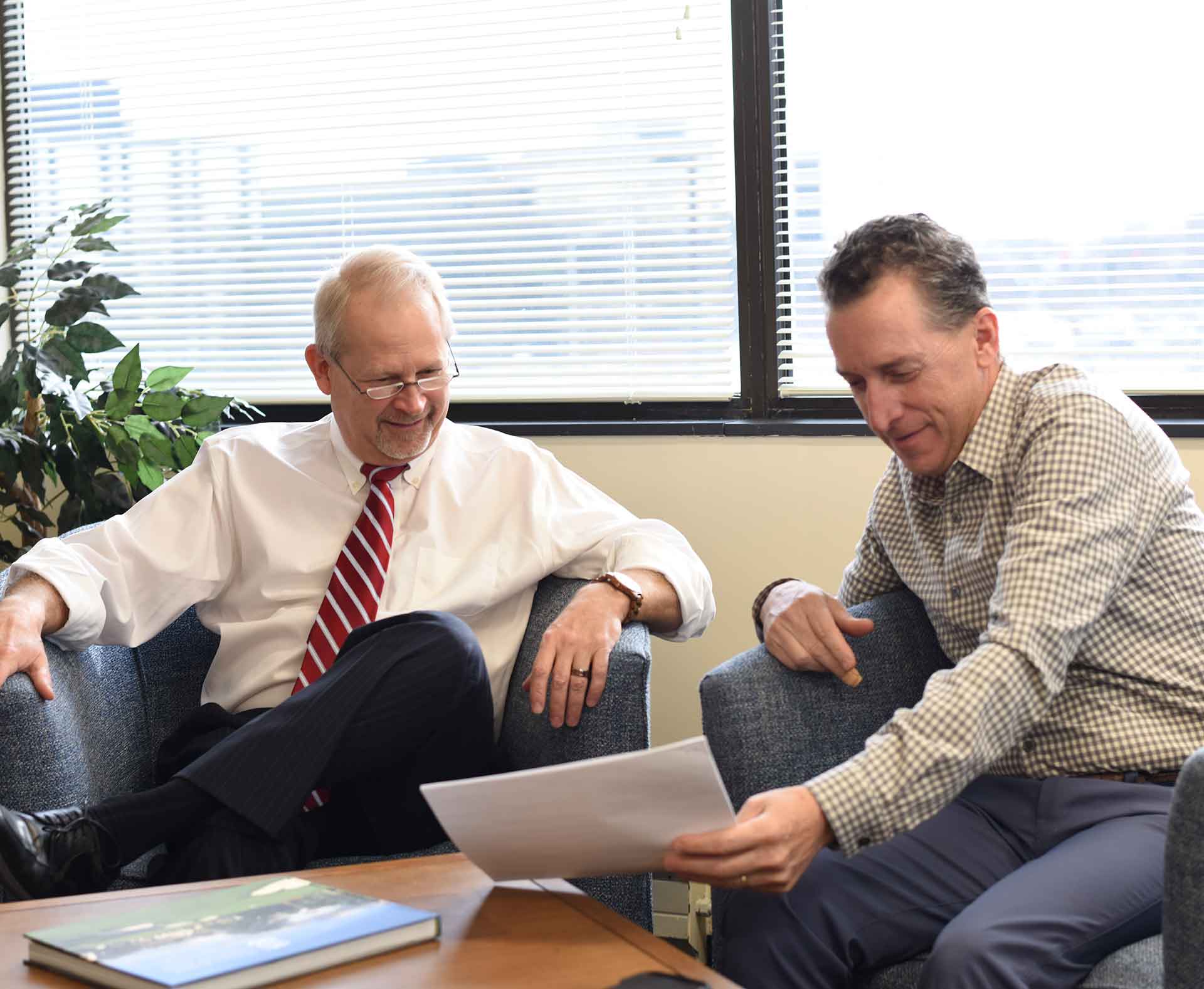 Two attorneys collaborating over a document in the office.